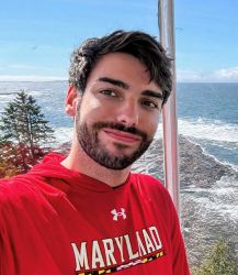 Headshot of a person in red shirt taken outside