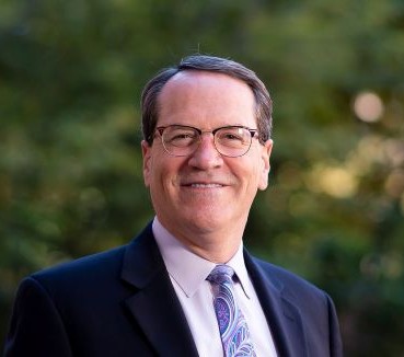 Outdoor headshot of person in business attire.